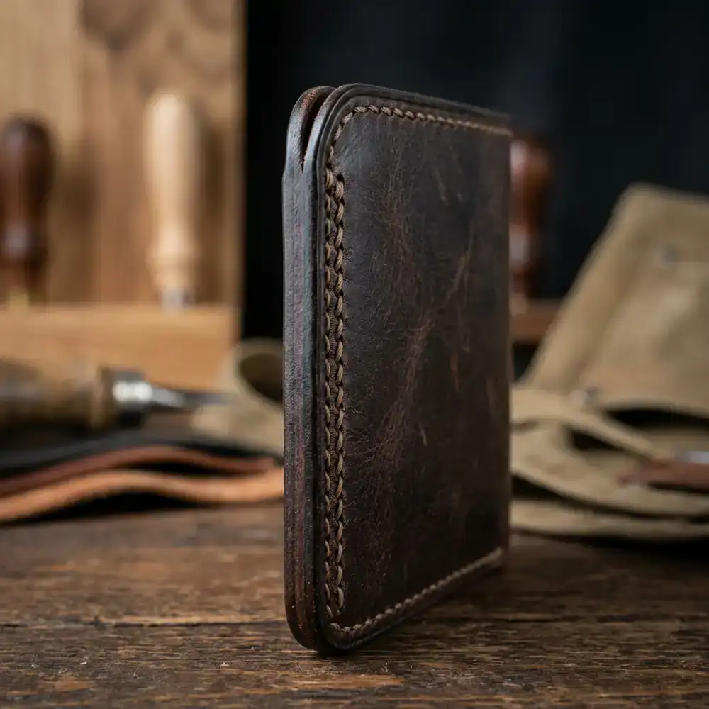 Detailed macro view of hand-stitching on a leather wallet edge